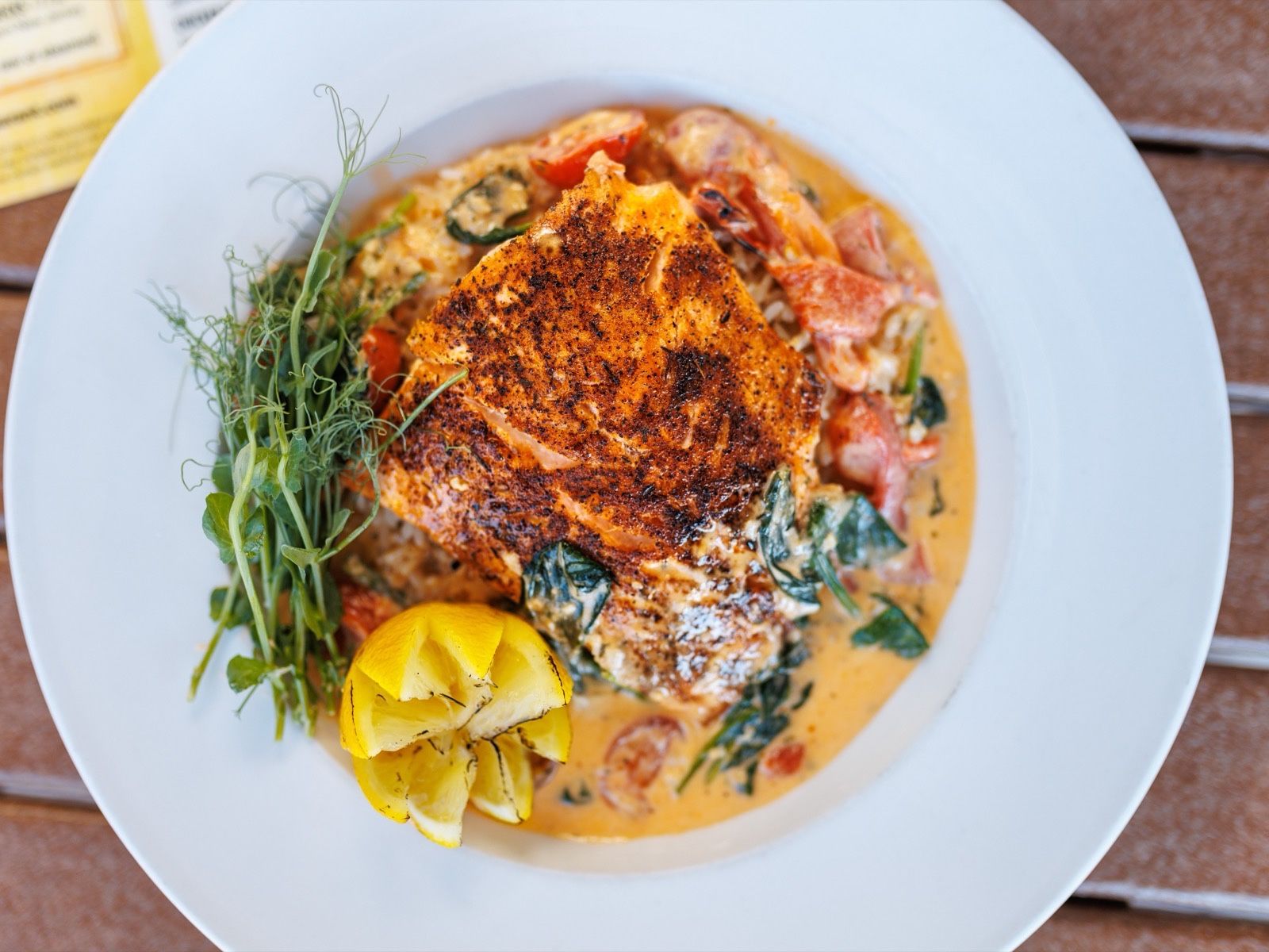 Blackened fish over rice with spinach, tomatoes and a lemon at Dive Bar Restaurant