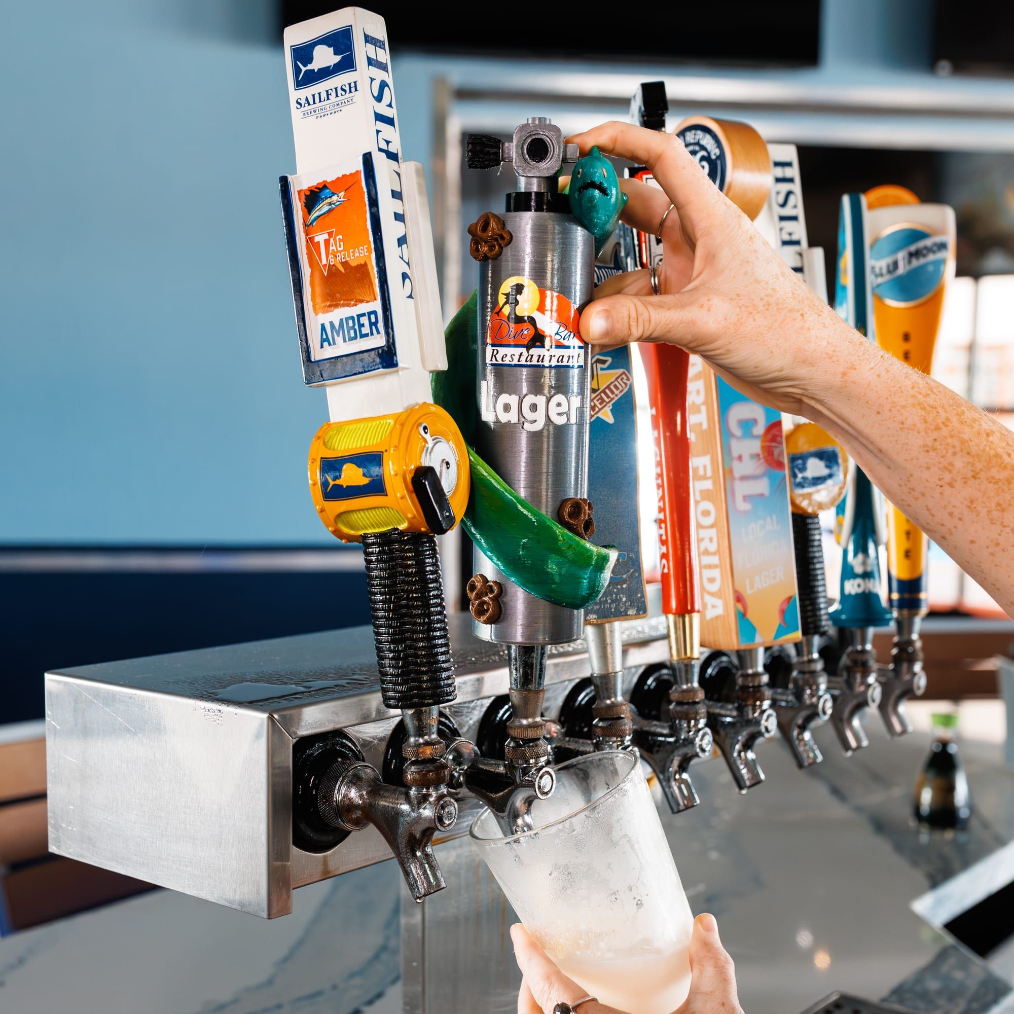 A Dive Bar Lager pouring from the tap wall behind the bar