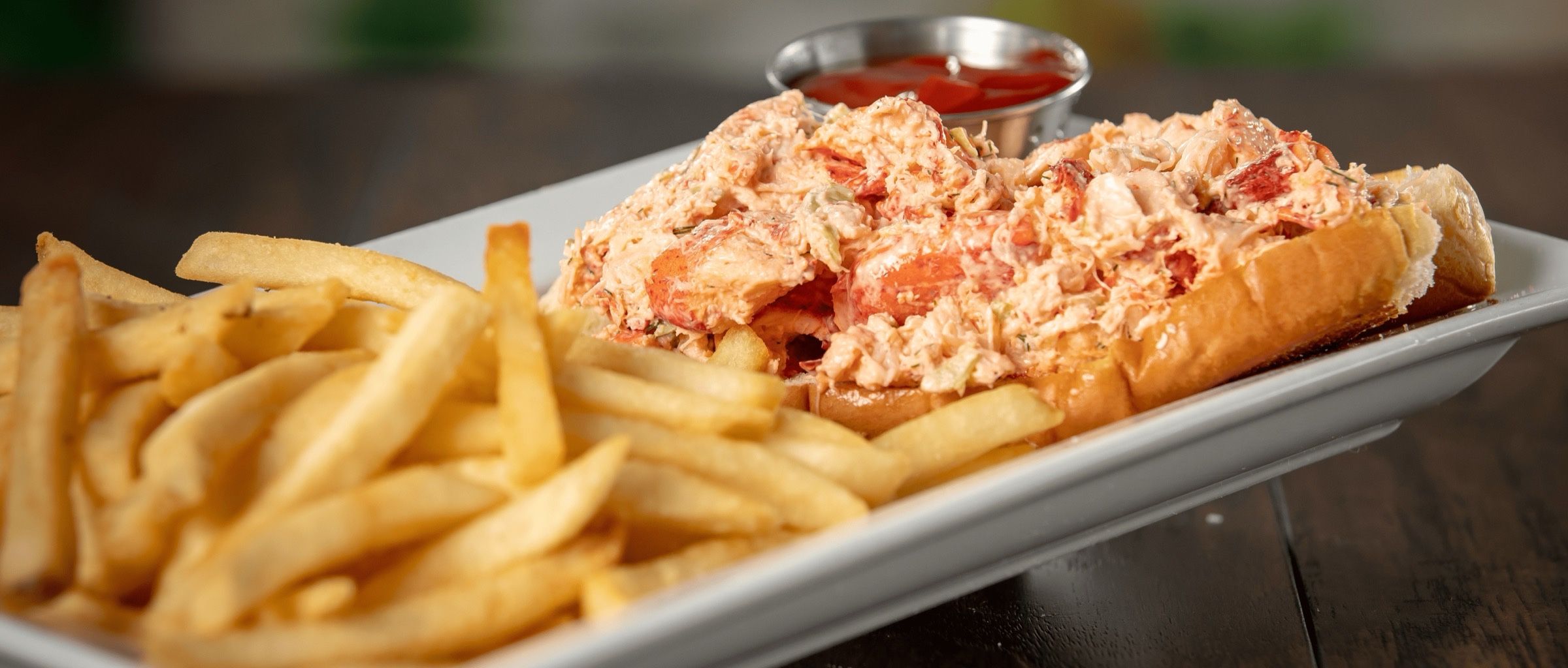 Maine lobster roll with fries at Dive Bar Restaurant