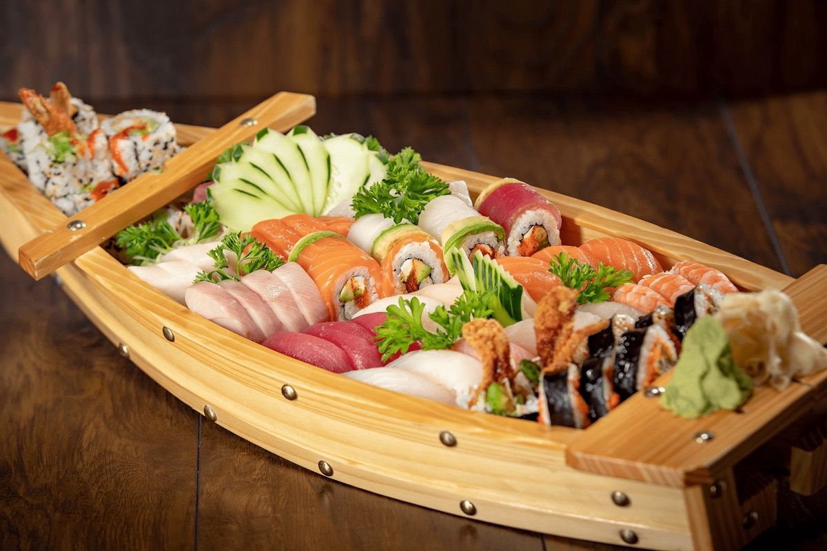 Assorted sushi and sashimi served on a wooden boat platter at Dive Bar Restaurant