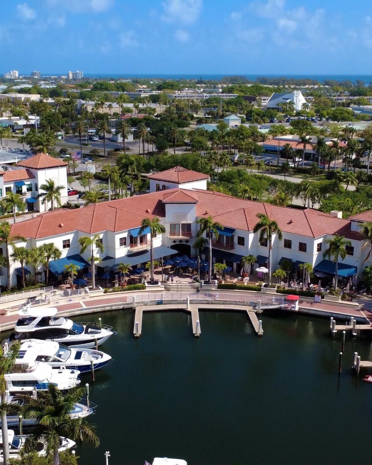 Aerial view of Dive Bar Restaurant and the boat slips at the Jupiter Yacht Club Marina, with the ocean on the horizon